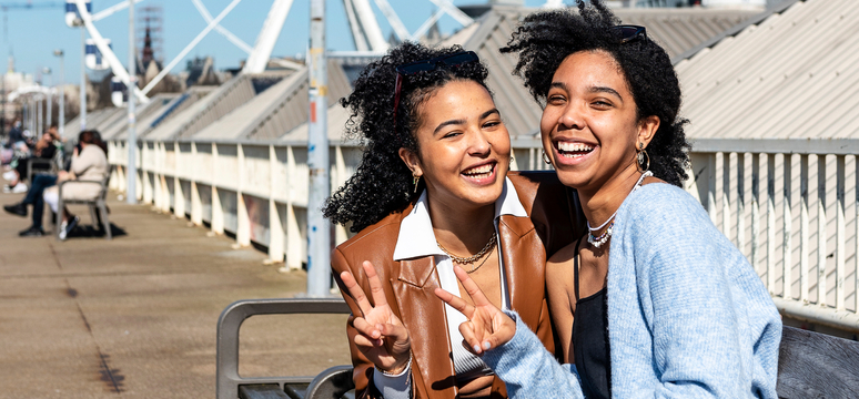 Twee jongeren op een bankje op de loopbrug aan de Kaaien